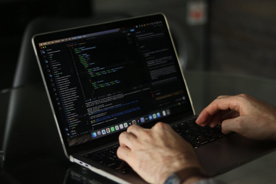 A close-up photograph of a computer screen displaying a code editor with an open HTML file named 'index.html.' The screen shows lines of code formatted with tags such as <html>, <head>, <title>, and <